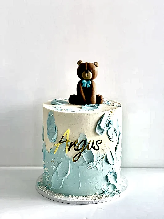pretty cake with a edible teddybear on top perfect for first birthday or baby shower